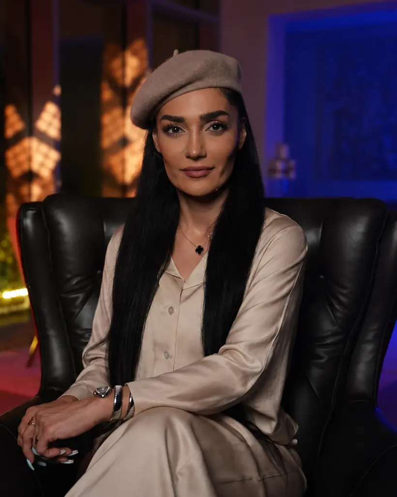 پریسا سرایی با لباس ساتن روشن روی مبل چرمی